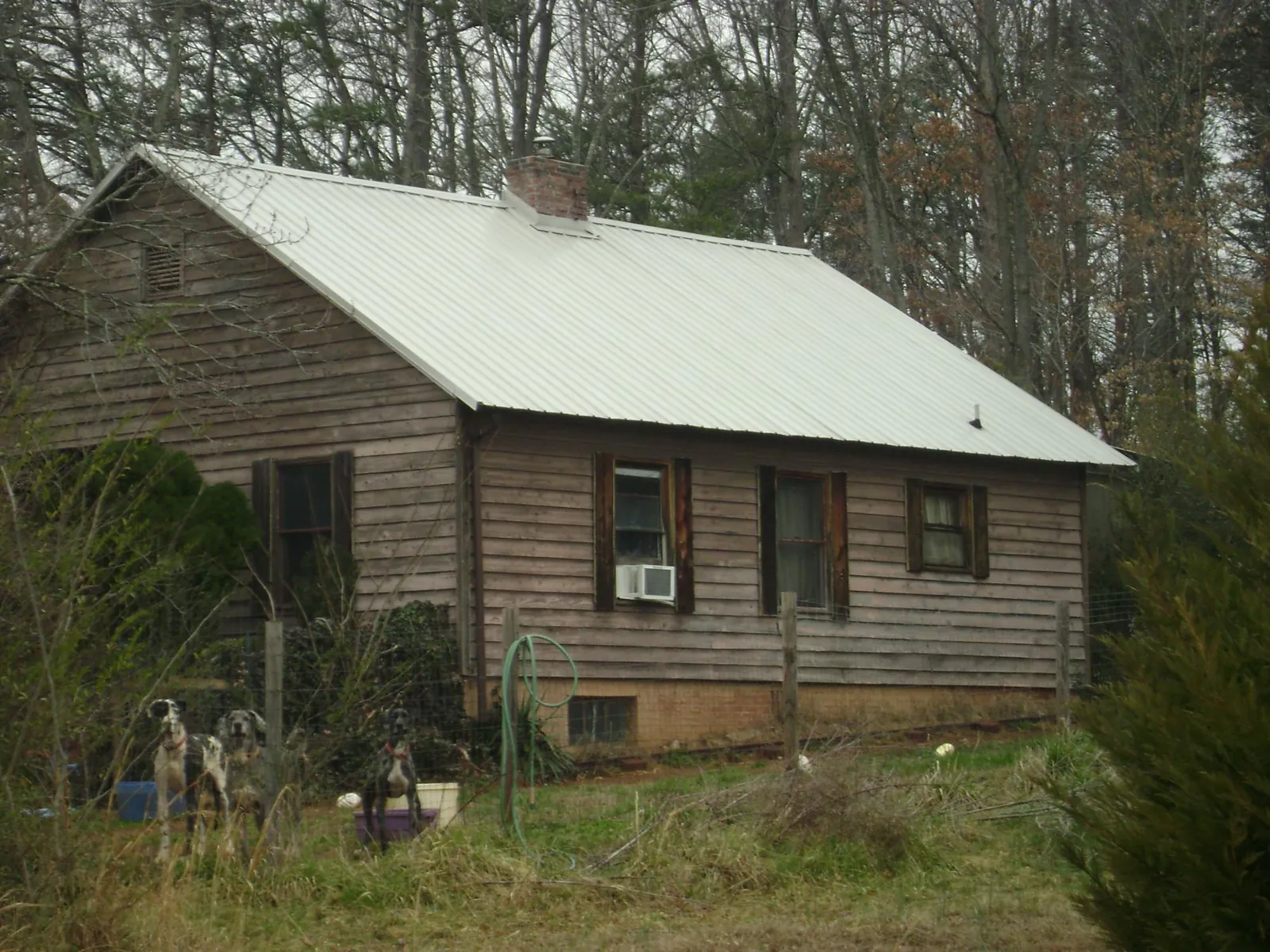White metal roof on an old wood sided farmhouse, from a Metal Roof Installation job in Valley City